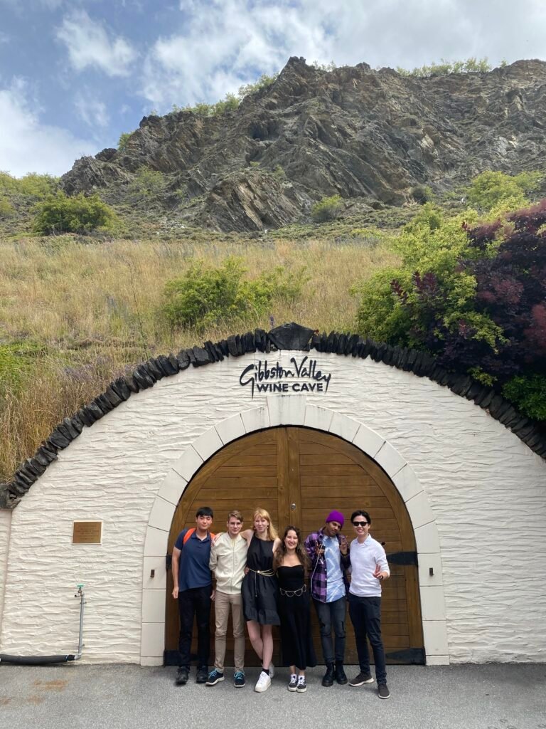 Group of friends standing outside the entrance to Gibbston Valley Wine Cave